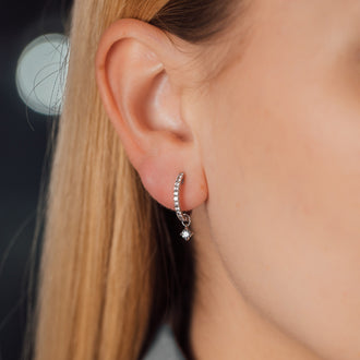 Detailaufnahme von Anhänger SOUL mit weißem Diamant an Ohrring in Weißgold getragen von Frau