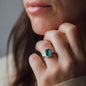 Frau mit grünem Diamantring an Finger