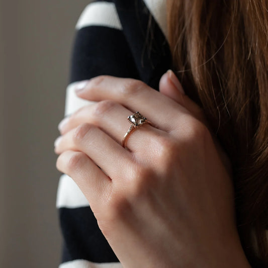 Hand von Frau mit großem Diamantring an Mittelfinger 