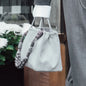 Handtasche mit Handtaschen Henkel Ricky in Grey vor Blumenbeet